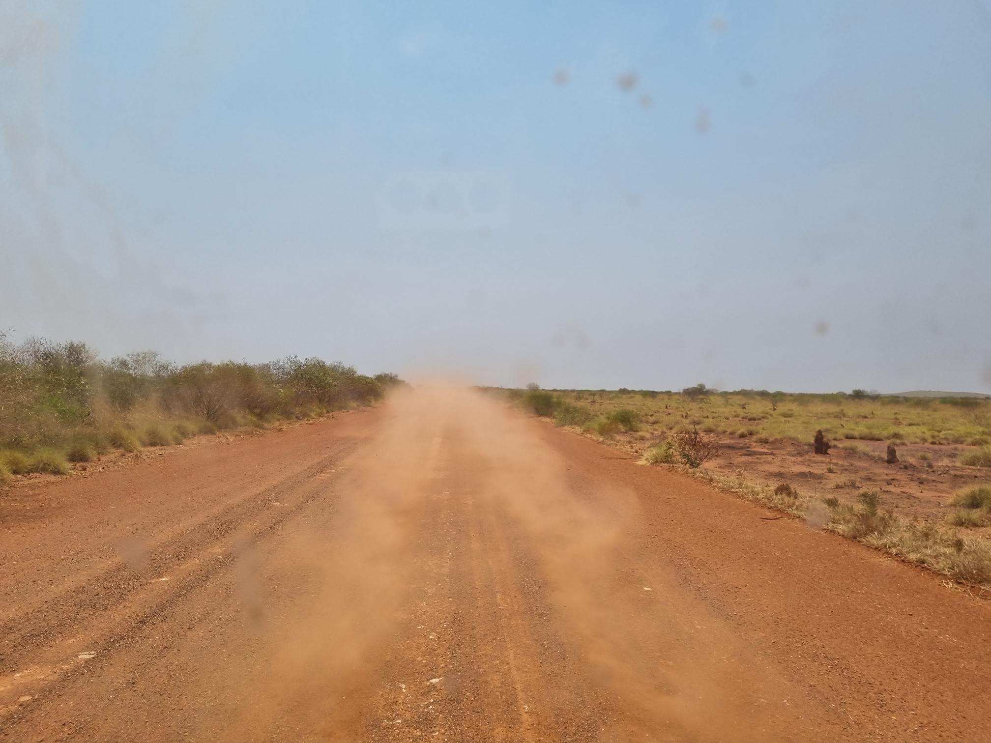 image of a dusty dirt road with blue sky